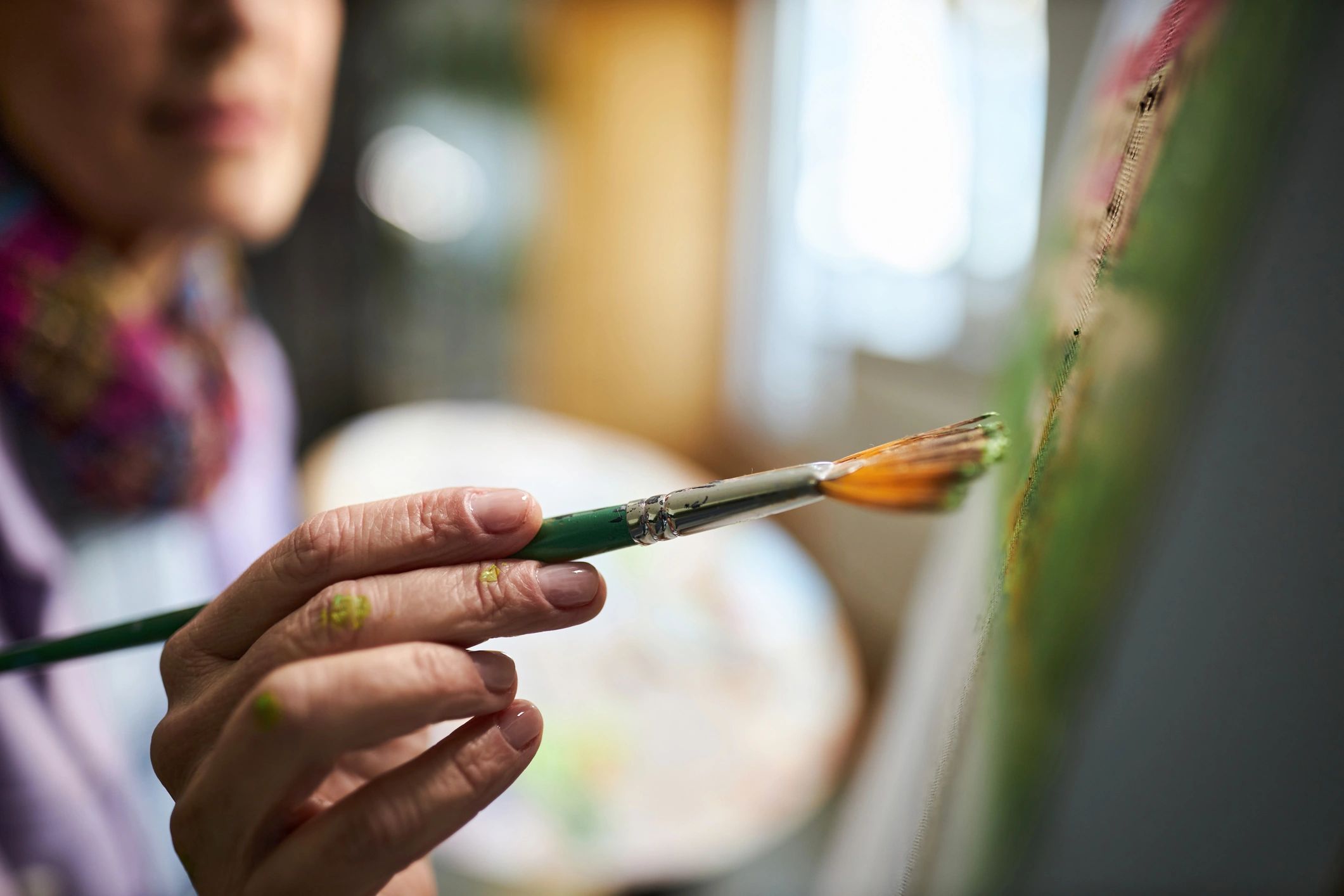 Atölyede tuval üzerine çalışan ressam